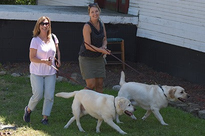 Mia Coulton and the MaryRuth Books team outside with two yellow Labs